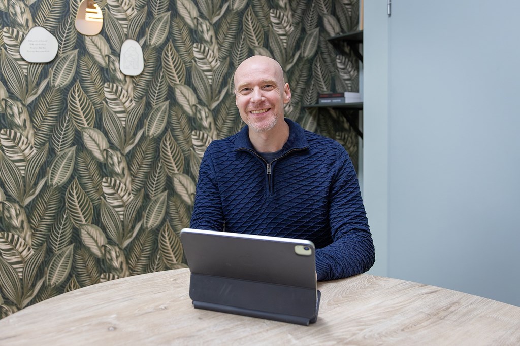 Makelaar van Romijn Makelaardij aan tafel op kantoor in Houten